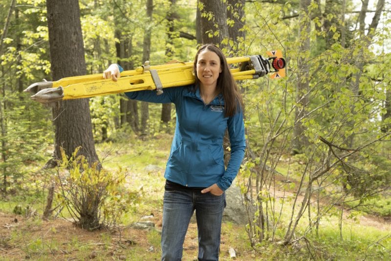 tara hartson posing with surveying equipment