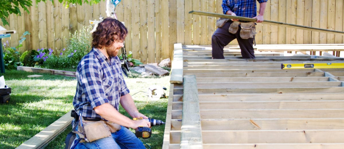 photo of men working on a deck in the summer